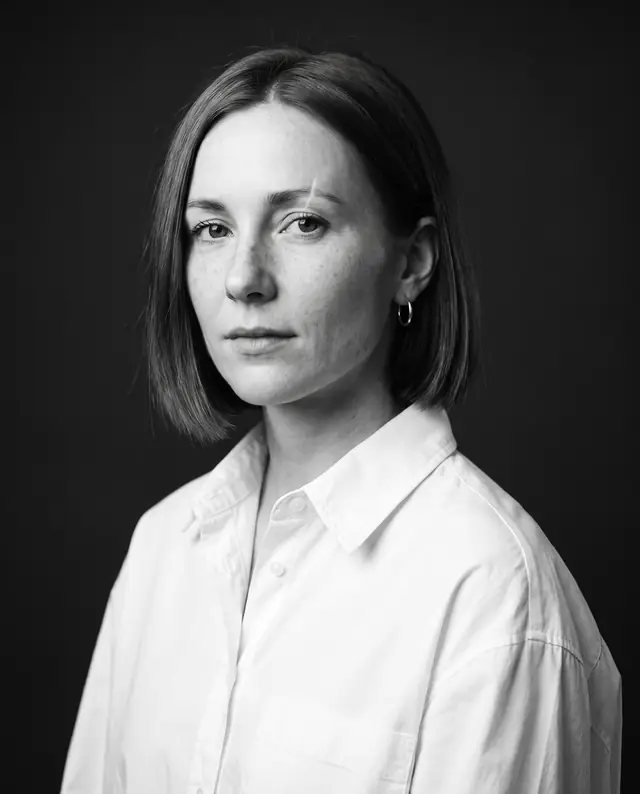 Black-and-white studio portrait of the same character